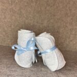 Two packs of handmade flannel and microfiber makeup remover pads tied with blue ribbon on grey felt