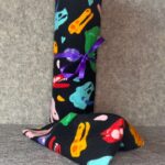 Muss Busters reusable towel roll in colorful dinosaur skull print on black background with purple ribbon