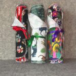 Three Muss Busters mixed print reusable towel rolls - Best Friend mix with red ribbon, Jungle mix with green ribbon, Festive mix with purple ribbon